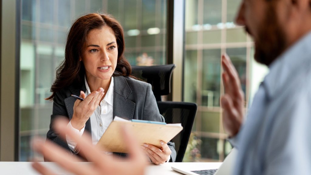 A professional business woman in a meeting, communicating strategically to create leverage and increase power in a locked negotiation.