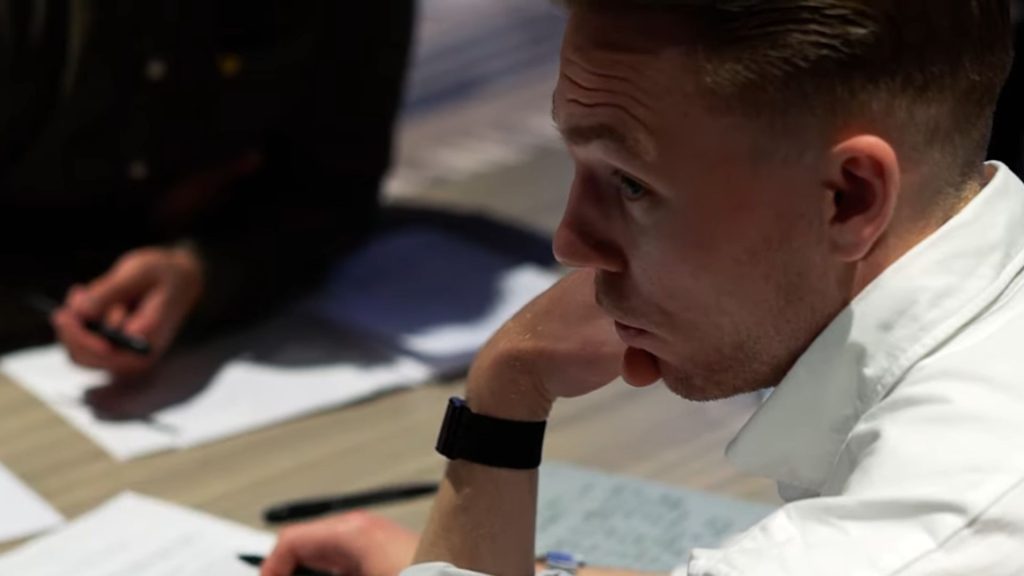 Professional negotiation training and contract analysis hosted by Wægger Negotiation Institute. The image shows two men reviewing strategies and numbers at a meeting table in a modern training room.